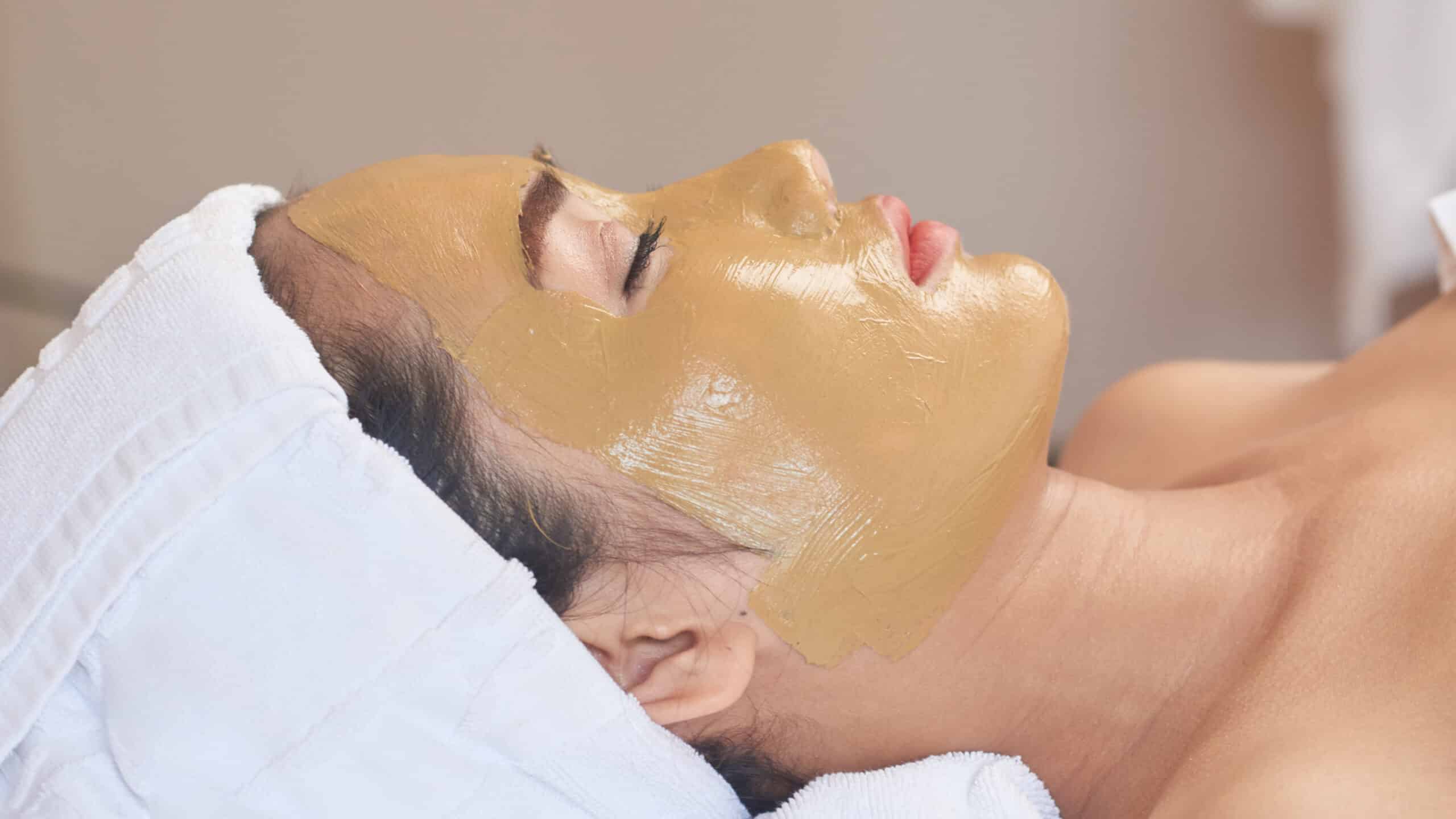 Máscaras Faciais Nutritivas e Calmantes 7 Young Asian woman relaxing in spa salon with clay mask on her face